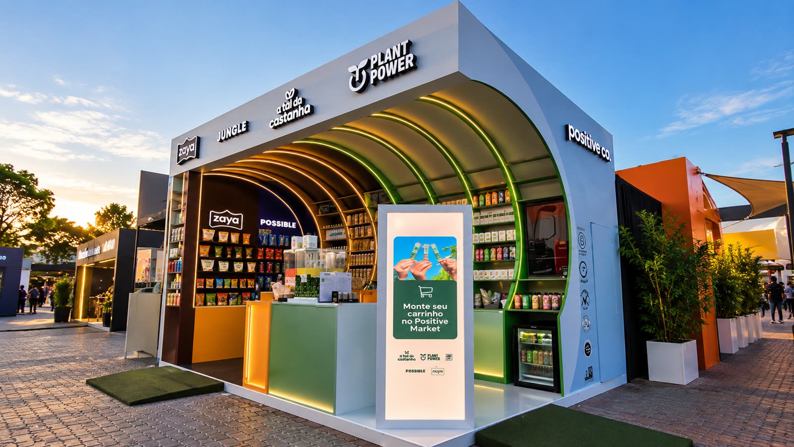 Cenografia da Plant Power ao ar livre ao entardecer, com arco verde iluminado e expositores