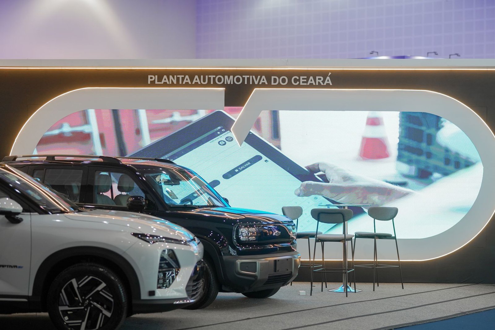 Painel de LED oval do stand PACE com dois veículos em exposição