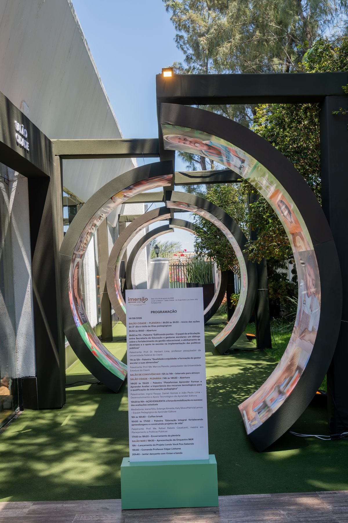 Arcos circulares cenográficos ao ar livre com painéis gráficos