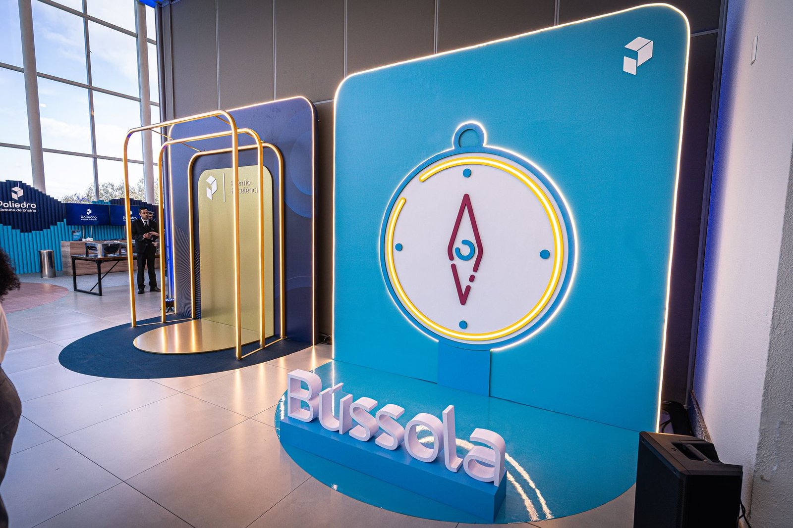 Ativação Bússola: portais dourados iluminados diante do painel azul com a bússola
