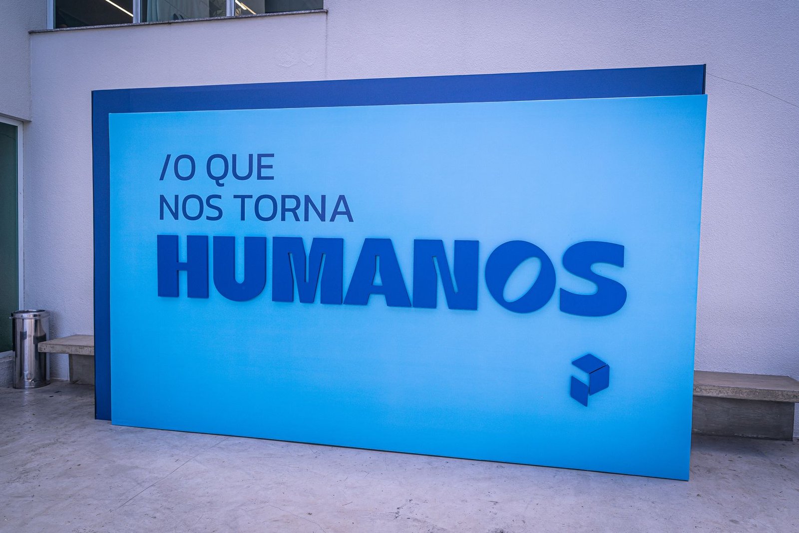 Painel cenográfico monumental com a frase O QUE NOS TORNA HUMANOS, em azul